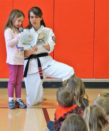 Karate sensei presents book at Cedar Mountain On left, a Kindergarten student reads, "The Black Belt ABC's," with Melissa La Cour on right.