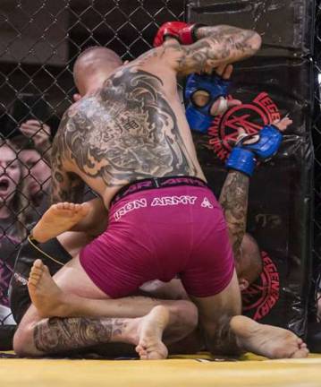 Sean Santella delivers strikes against the cage in front of a partisan crowd full of Miller Brothers MMA &amp; Fitness supporters.