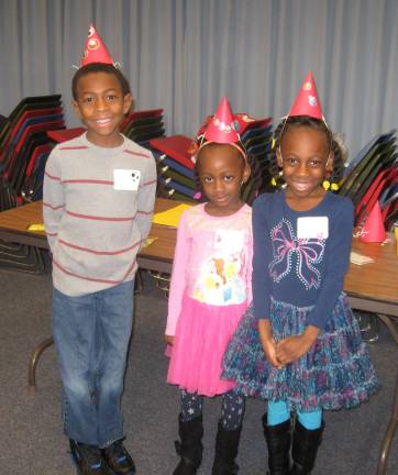 PHOTOS BY JANET REDYKE Siblings Joshua, Stella and Hadassah Jean happily anticipate the start of the After- Christmas party.