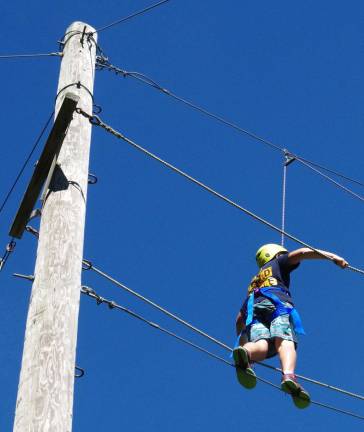 A Glen Meadow Middle School student is shown high above the ground on the school&#xfe;&#xc4;&#xf4;s Catwalk segment of the Rope Course during the Team Adventure program.