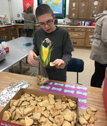 Robbie Peters packages the dog biscuits, which come in a variety of sizes for big and small dogs.