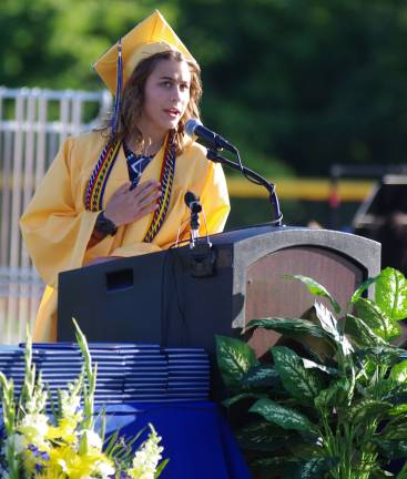 Graduate Emily Rothamel stands at the podium during the flag salute.