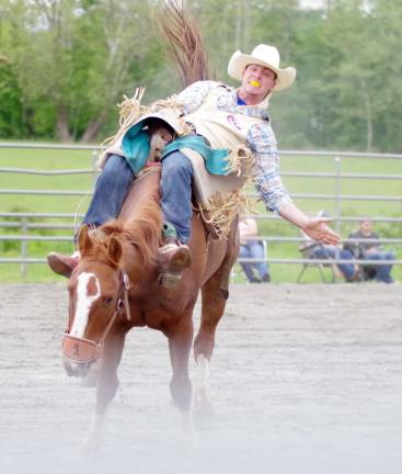 Green Valley Farm hosts rodeo An angry horse carries it's rider towards the camera during the bareback riding event.