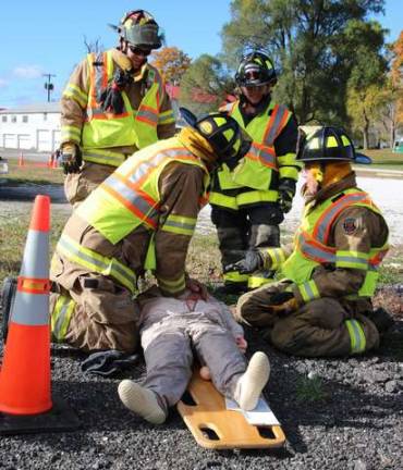 Members of the Beemerville Fire Dept. work on a victim of a staged bus crash.
