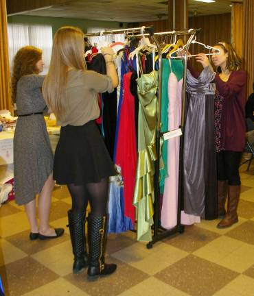 &#xfe;&#xc4;&#xfa;Project Princess Dress Drive&#xfe;&#xc4;&#xf9; organizers Emily Garosall, left, Simone Marchesin, center, and Jenna Day, right, adjust the semiformal and prom dresses that will be given away.