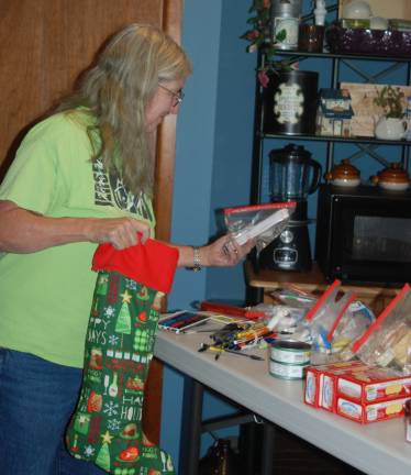 Elaine Hossfield, Vernon Township Woman&#xfe;&#xc4;&#xf4;s Club board member and State Chairperson for the &quot;Boatsie&#xfe;&#xc4;&#xf4;s Boxes Project&quot;, fills hand made Christmas Stockings to provide holiday cheer to troops deployed overseas.