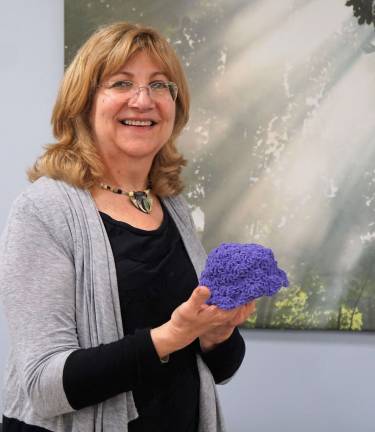 Karen Rothstadt holds one of the purple baby hats which will be sent to N.J. hospitals in order to help prevent Shaken Baby Syndrome.