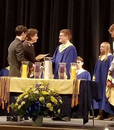 Christopher Hainzl receives his certificate from Principal Dr. Pauline Anderson as chapter president Dan McKeon assists.