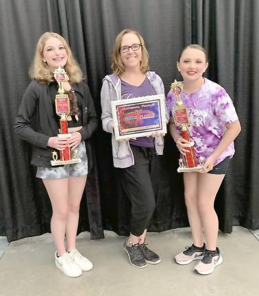 Miss Kelly Daucus-Smith, center, is honored with a Choreography Award. She is flanked by two Dance Expression dancers.