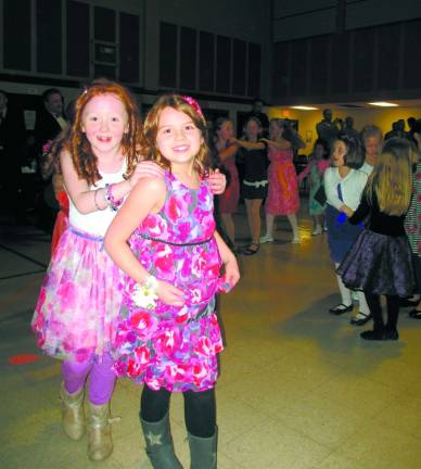 Fathers, daughters try on their dancing shoes Second-grader Sofie teitsma, 7, leads the conga line.