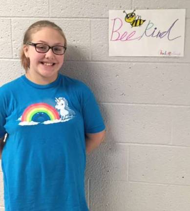 Ogdensburg students complete 2,500 acts of kindess Ogdensburg student Charlotte Gough stands by the poster she made to remind everyone to be kind.