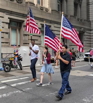 Happy Birthday America! Little Known but Lively 4th of July Parade Wows Lower Manhattan Grand Marshal and Assembly Member Charles D. Fall (left) whose district includes part of lower Manhattan as well as Staten Island and parts of Brooklyn, carries an American flag in the Independence Day parade in lower Manhattan on July 4.