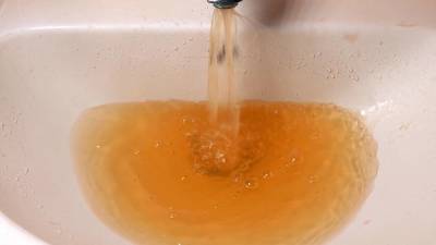 An example of brown water pouring from a tap.