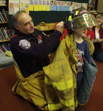 Never too young to learn about fire safety The boys and girls got to try on Bob Winter’s coat and helmet.