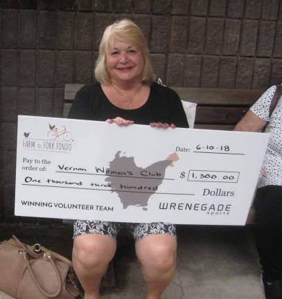 PHOTO BY JANET REDYKEMaria Dorsey of the Vernon Woman's Club displays a check for $1,300 that the club received from the Farm to Fork Fondo Bike Race held this spring.
