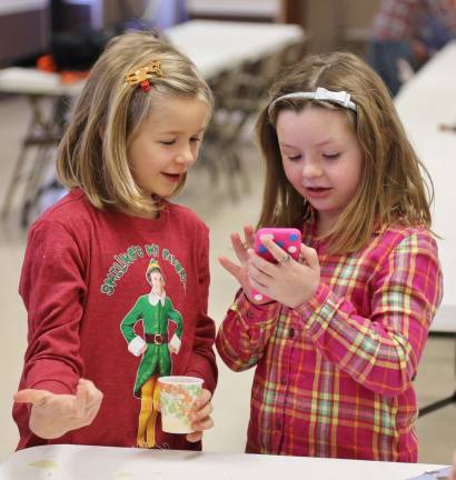 Emma Feichtl of Wantage and Hailey Hanshaw of Sussex pick out their favorite tunes at the Sussex breakfast with Santa.