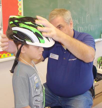 Learning about health Chase Berberich gets fitted by Trans- Options' Denis Kelleher for a complimentary bike helmet
