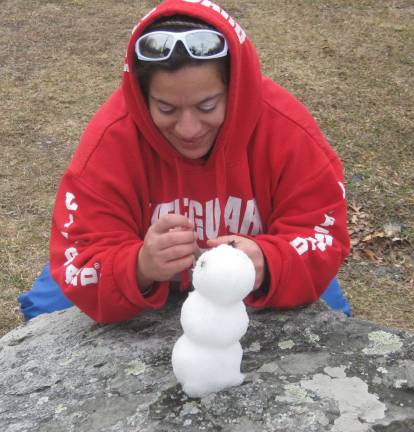 Visitor Laura Van Boerum of West Milford creates her own mini snowman from remnant snow.