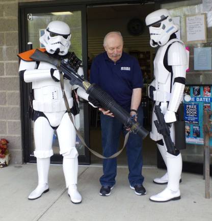From the left, Stormtrooper TK-27200 (Andrew Della Iacono of Oakland), Bob's Collectables storeowner Bob Adams, and Stormtrooper TK-41066 (Chris Manning of Vernon) stand in front of the store. Both stormtroopers are members of Northeast Remnant, 501st Legion.