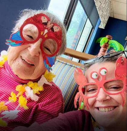 Homes away from home A resident poses with staff during a Hawaiian luau celebration at Belle Reve.