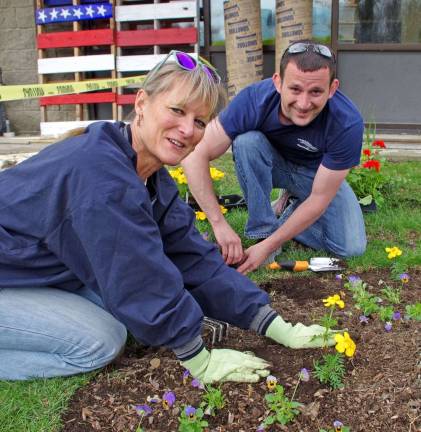 Volunteers Margaret Kranz and Tom Mikolay, both employees of Valley National Bank, plant flowers in front of the Vernon PAL building. The flowers were donated by Vernon Chamber Charities.