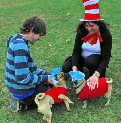 DeAnna Smidt and her son, Justin, of Highland Lakes prepare the costumes for their Jack Russell/pug mix dogs. The dogs wore Thing 1 and Thing 2 costumes.