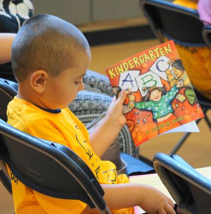 PHOTOS BY VERA OLINSKI A student examines his new book.