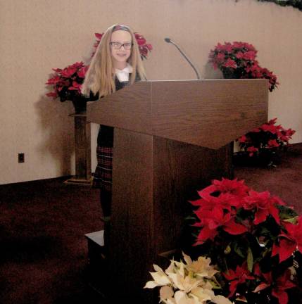 Third-grader Erin King of the Rev. Brown School talks about her school and daily educational activities at the 10 a.m. mass at St. Francis de Sales Church. Catholic Schools Week is celebrated from Jan. 29 to Feb. 4 with this year&#xfe;&#xc4;&#xf4;s theme being Communities of Faith, Knowledge and Service.