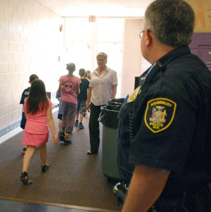 File photo Under the watchful eye of a Town of Woodbury Police officer, students evacuate Central Valley Elementary Schoolin May 2013 as part of a planned drill.