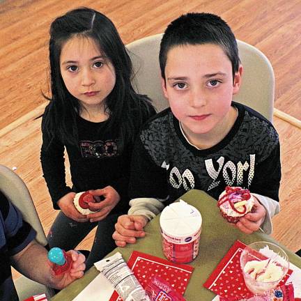 Barry Lakes hosts decorating cake Julie Evanick, 6, and her brother Michael, 7, with two of their cupcakes.