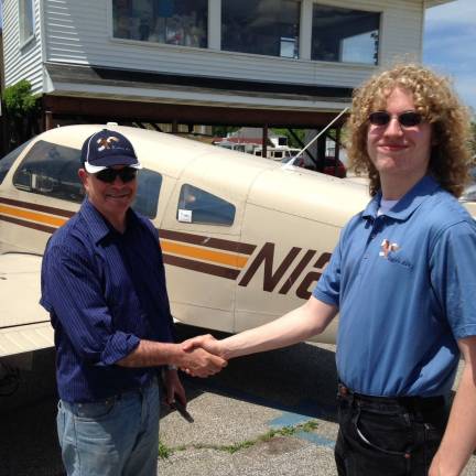 Christian Tracy, right, recently completed his first solo flight. Instructor and Eagles Arie owner Arie Fussman.