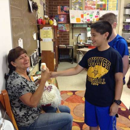 Students in Nancy Grimaldi's seventh-grade Language Arts class pet Oliver, a Sebastopol goose, as owner Leesa Beckmann holds him.