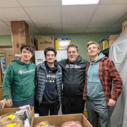 Community food pantry turns 40 Volunteers Billy Karipides, Matt Onorato, Christian Macchio and Matt Attala help distribute holiday meals in 2023. (File photo)