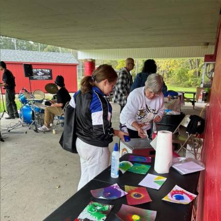 Sussex Borough Community &amp; Cultural Events Advisory Committee member Linda McGee helps at the spin art table.