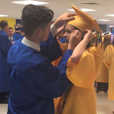 One Vernon Township High School senior helps another with her graduation cap prior to the ceremonies on Friday night.