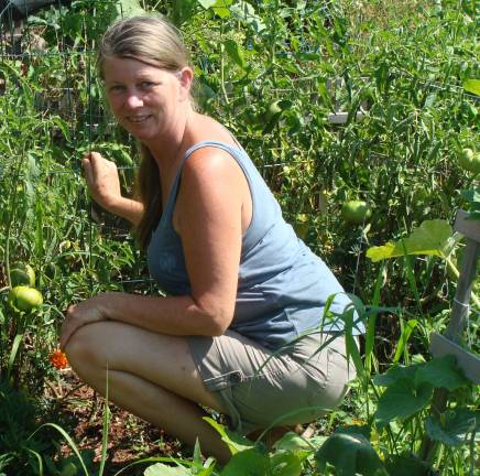 Another gardener checks her crops at the Vernon Community Garden.