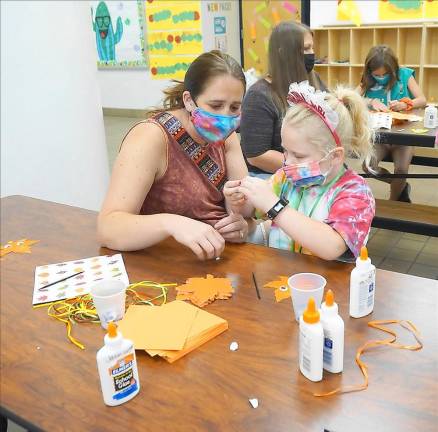 Madison enjoys making a craft with her mom (Photo by Vera Olinski)