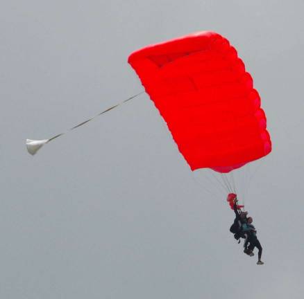 Tandem skydivers are shown descending above Sussex Airport during the third annual &quot;That's How We Roll Boogie&#xfe;&#xc4;&#xf9; skydiving event.