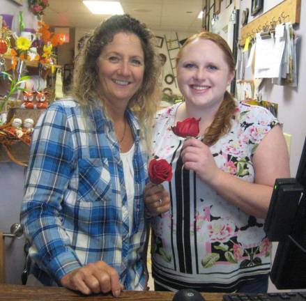 Highland Flowers owner Lori Struck and employee Jodi Bischoff display beautiful red roses.