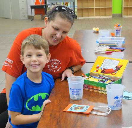 A mother and son enjoy making an &quot;Education is a Treasure!&quot; craft.