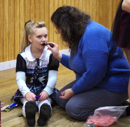 Barry Lakes resident Katie Molini, 9, sits patiently as her mother Mary Ann applies some monster makeup.