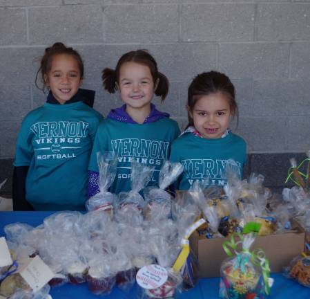 Vernon Girls Softball League players Isabella E. (6), Tessa Pelak (5) and Haley Gros (5) pose with bake items they were selling for a fundraiser.