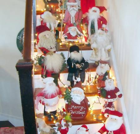 Many Santas decorate a stairway at the Manor House of Lusscroft Farms.