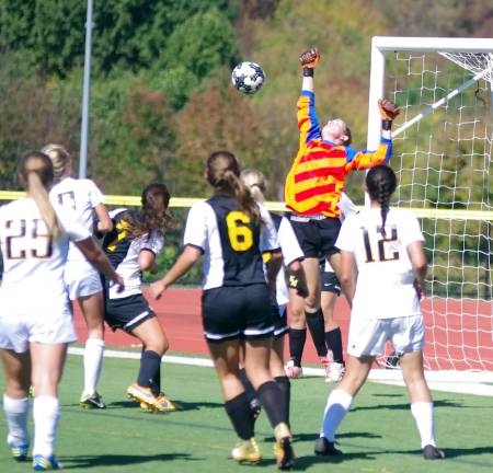 The ball is deflected away from the net by the raised arm of West Milford goalkeeper Natalie Marzalik.