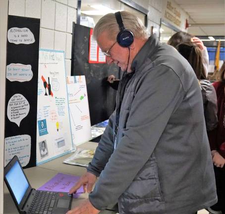 Vernon School Board Member Edward DeYoung listens to a 7th and 8th grade Myth and Fact project.