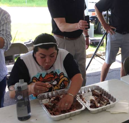 First-time female contestant Romelia Roman (left) of O.S.C.A.R.&#xfe;&#xc4;&#xf4;s Animal Rescue in Sparta and eventual winner Andy Garger from the Sparta Education Foundation compete in the 7th annual Rock, Ribs &amp; Ridges &#xfe;&#xc4;&#xfa;Rib Eating Challenge&#xfe;&#xc4;&#xf9; on Saturday, June 10 held at Franklin Sussex Auto Mall in Sussex, NJ. Garger downed a full rack of ribs in 4 minutes 11 seconds to beat out contestants from six other local non-profit groups in the annual fundraising event held by the upcoming Rock, Ribs &amp; Ridges music and food festival, June 24-25, at the Sussex County Fairgrounds and by festival presenting sponsor Franklin Sussex Auto Mall.