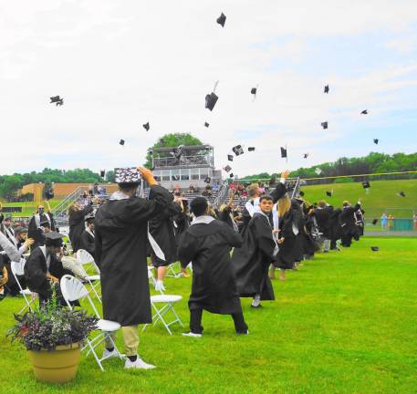 Students throw their caps in the air. (Photo by Vera Olinsky)