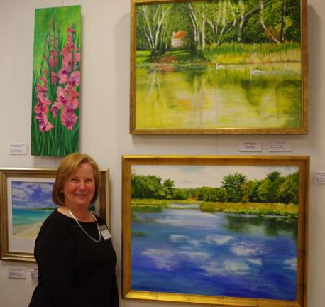 Patricia Whittle of Green Township stands beside her winning painting &#x201c;Swans on the Pequest.&#x201d; Whittle and MaryAnn Grib were the two finalists in the monthly competition.