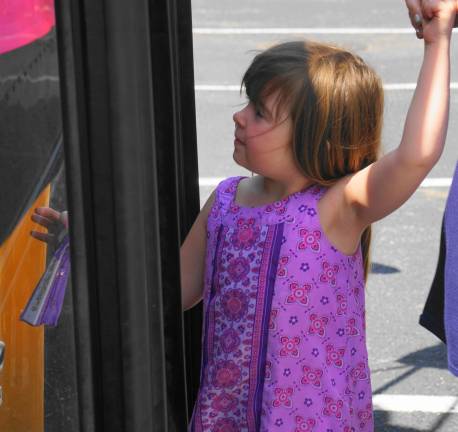 A Kindergarten student enters the bus.