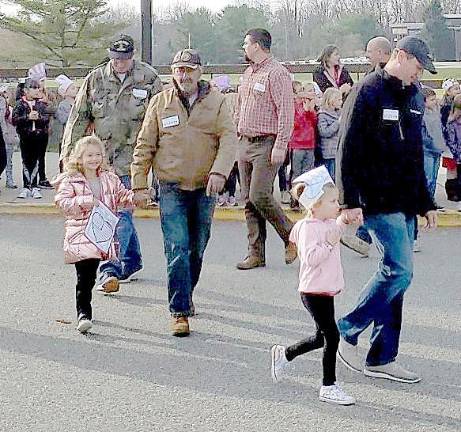 Two Students from Cedar Mountain walk proudly with their Veteran family members.